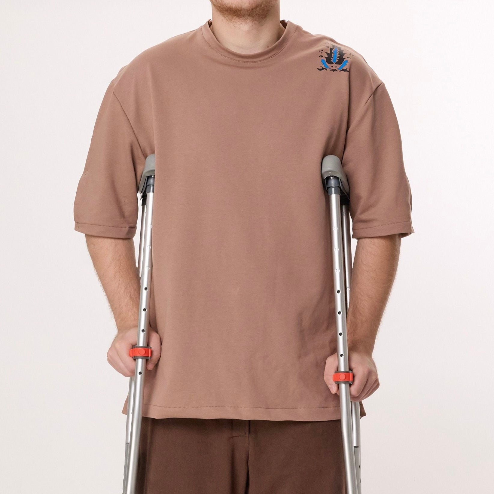 Person using crutches on a plain background